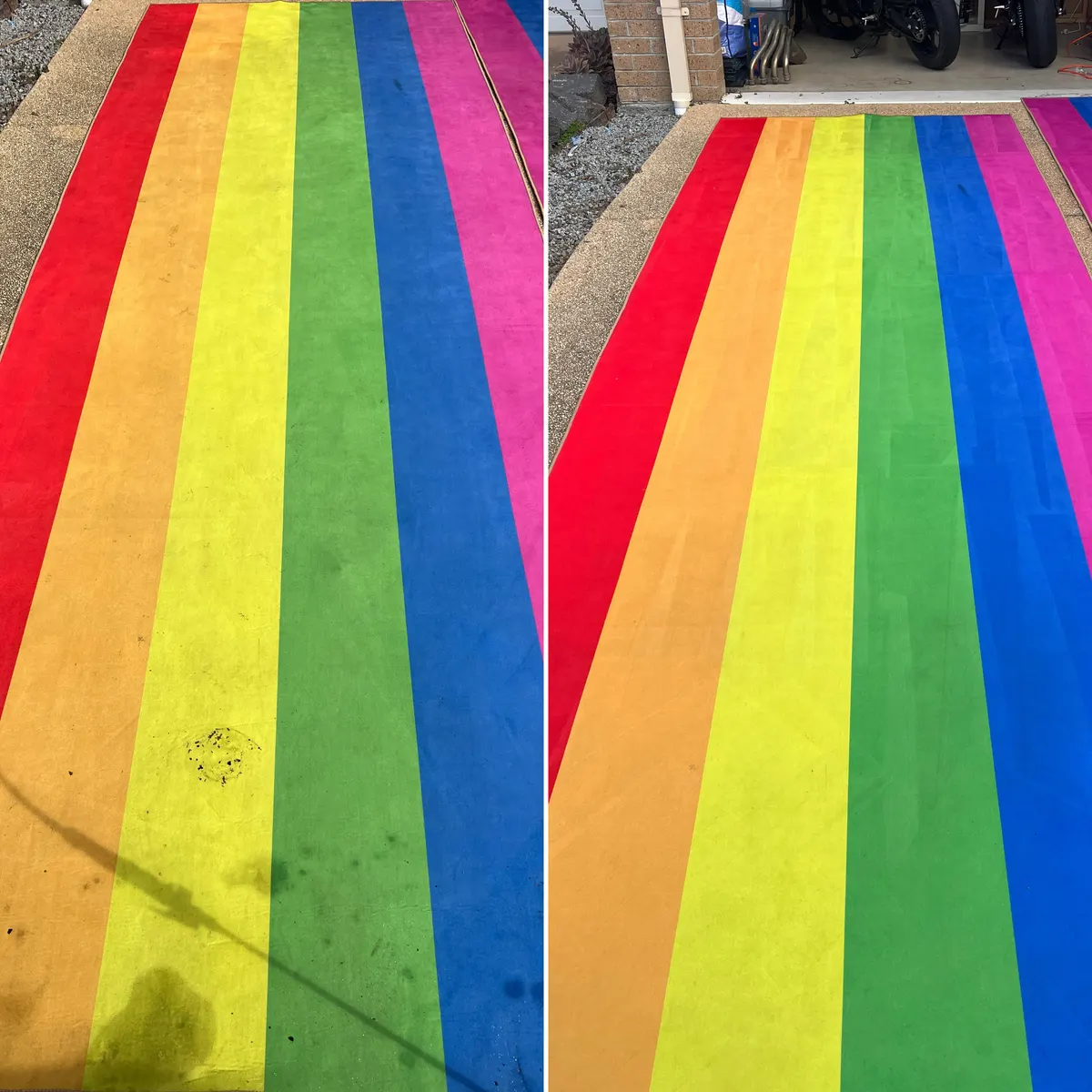 A rainbow-striped runner rug on a Sanctuary Lakes driveway, before and after cleaning. The dark blotch on the yellow stripe and the grey film over the colours are gone.