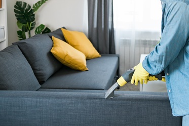 Upholstery cleaning services Person cleaning a couch,